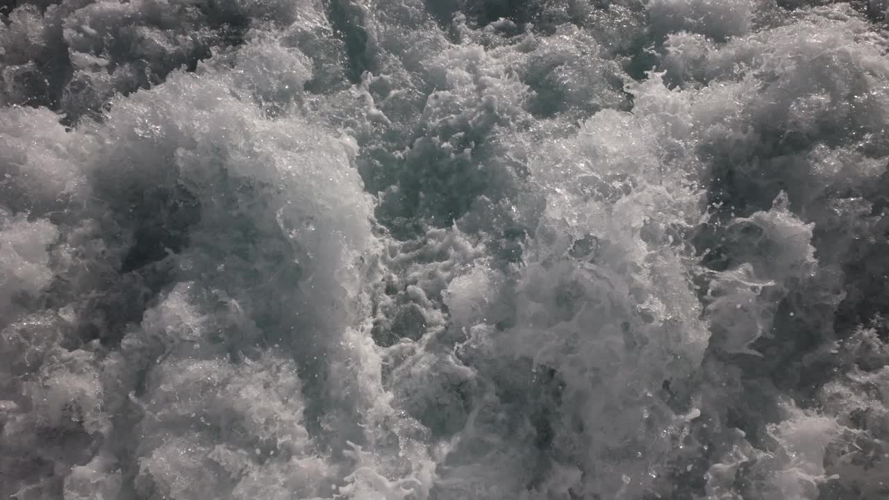 船后尾迹中飞溅的水湍流的近景。视频下载