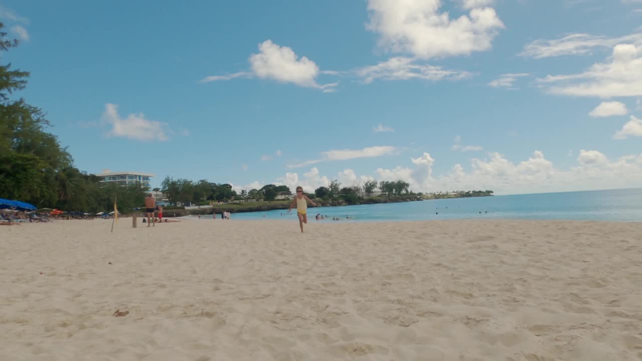 海滩欢乐:5岁女孩微笑着跑向镜头视频下载
