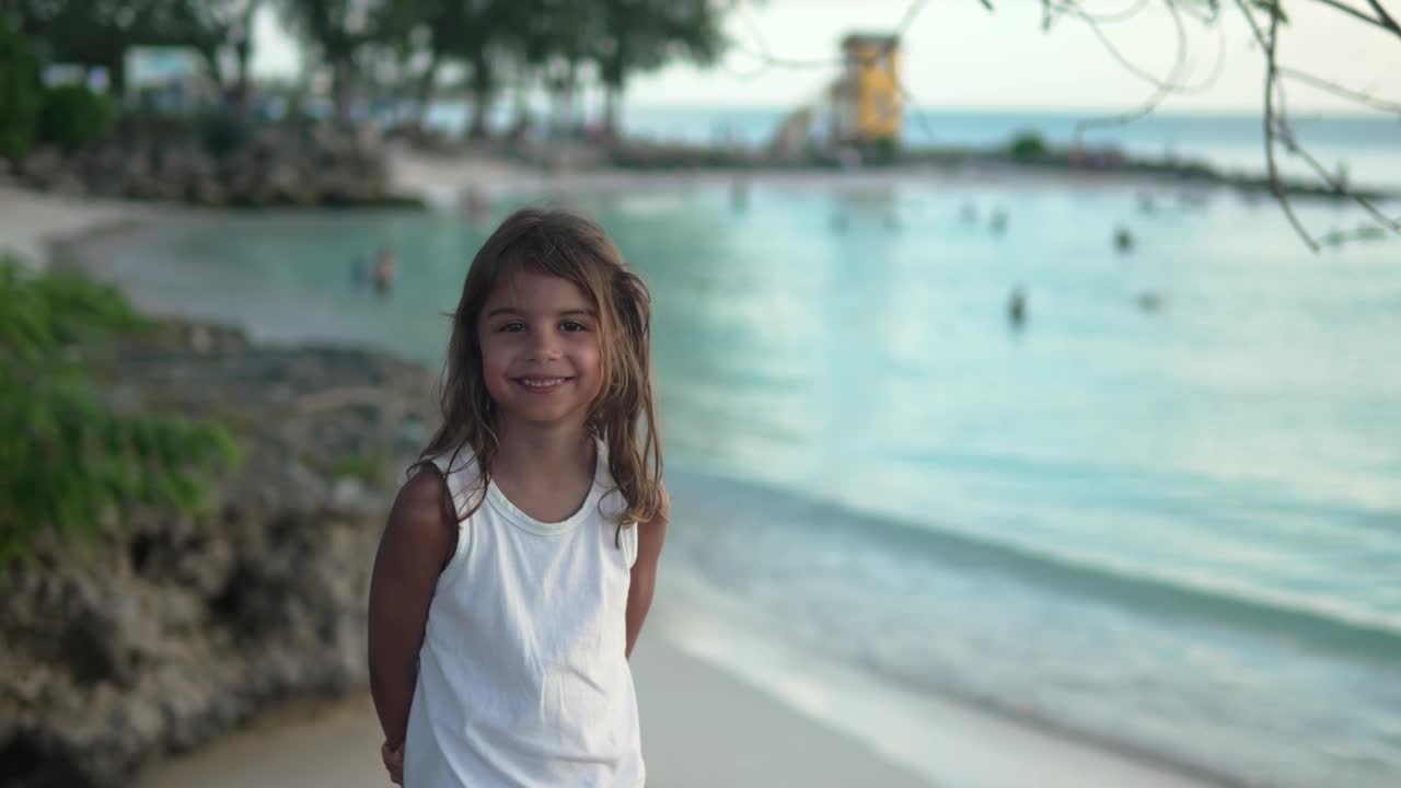 巴巴多斯企业海滩上快乐的5岁小女孩，偷拍的照片视频下载