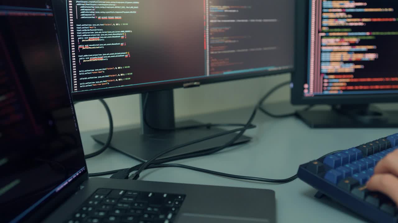 特写年轻的软件开发人员使用电脑编写代码，为人工智能技术开发应用程序，在办公桌上使用多屏幕在家办公。程序员开发。视频下载