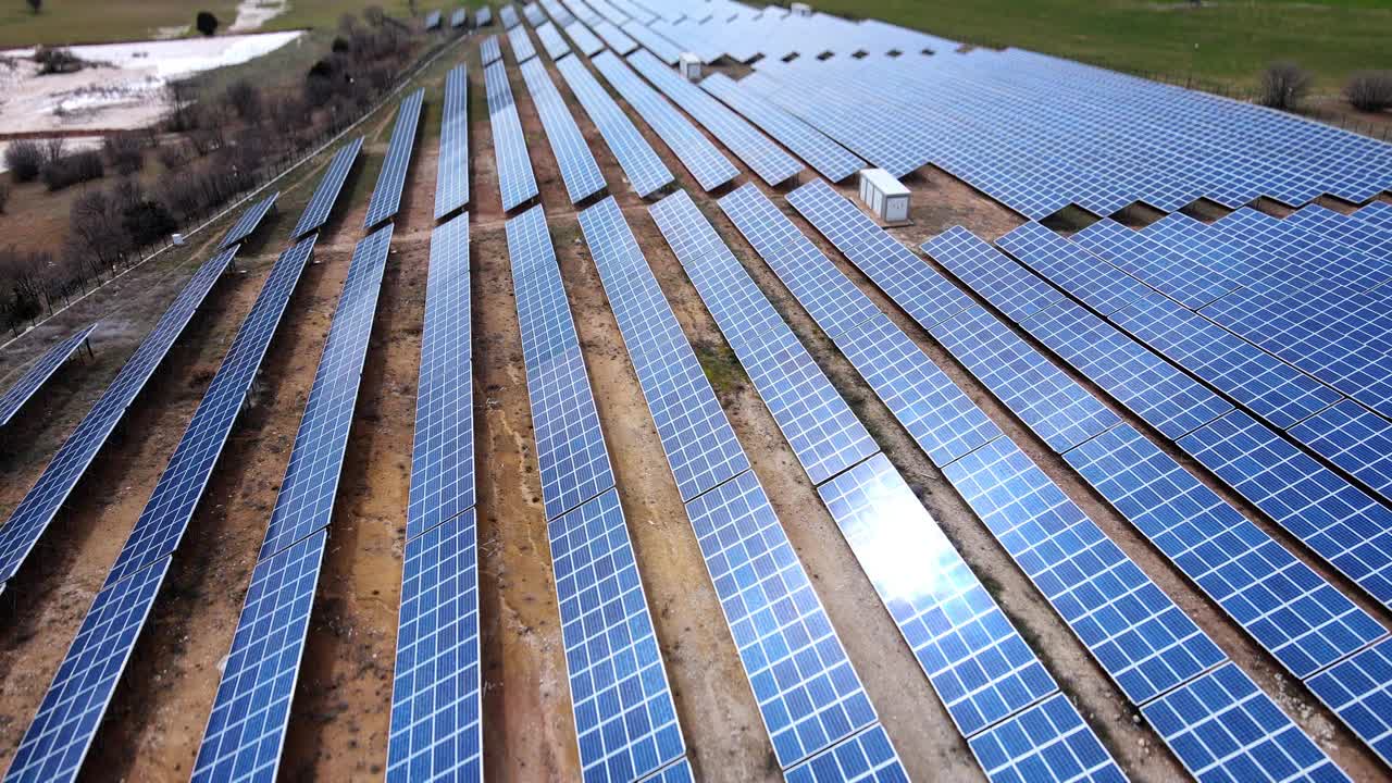 太阳能电池板大规模阵列产生可再生能源。可持续能源和资源背景。无人机航拍图视频下载