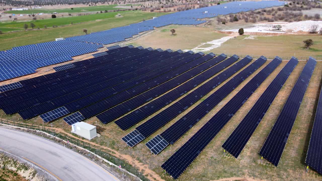 太阳能电池板大规模阵列产生可再生能源。可持续能源和资源背景。无人机航拍图视频下载