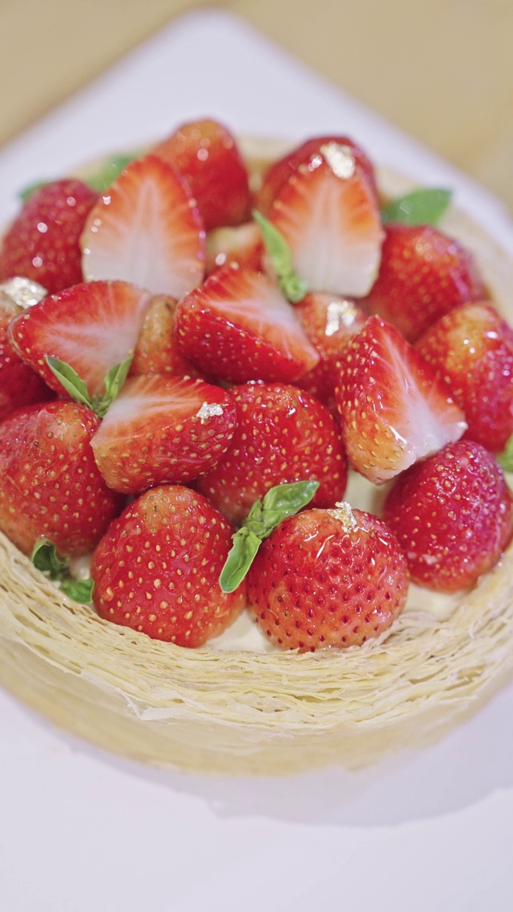 用镊子在草莓芝士蛋挞蛋糕上手工装饰一小片金箔视频下载