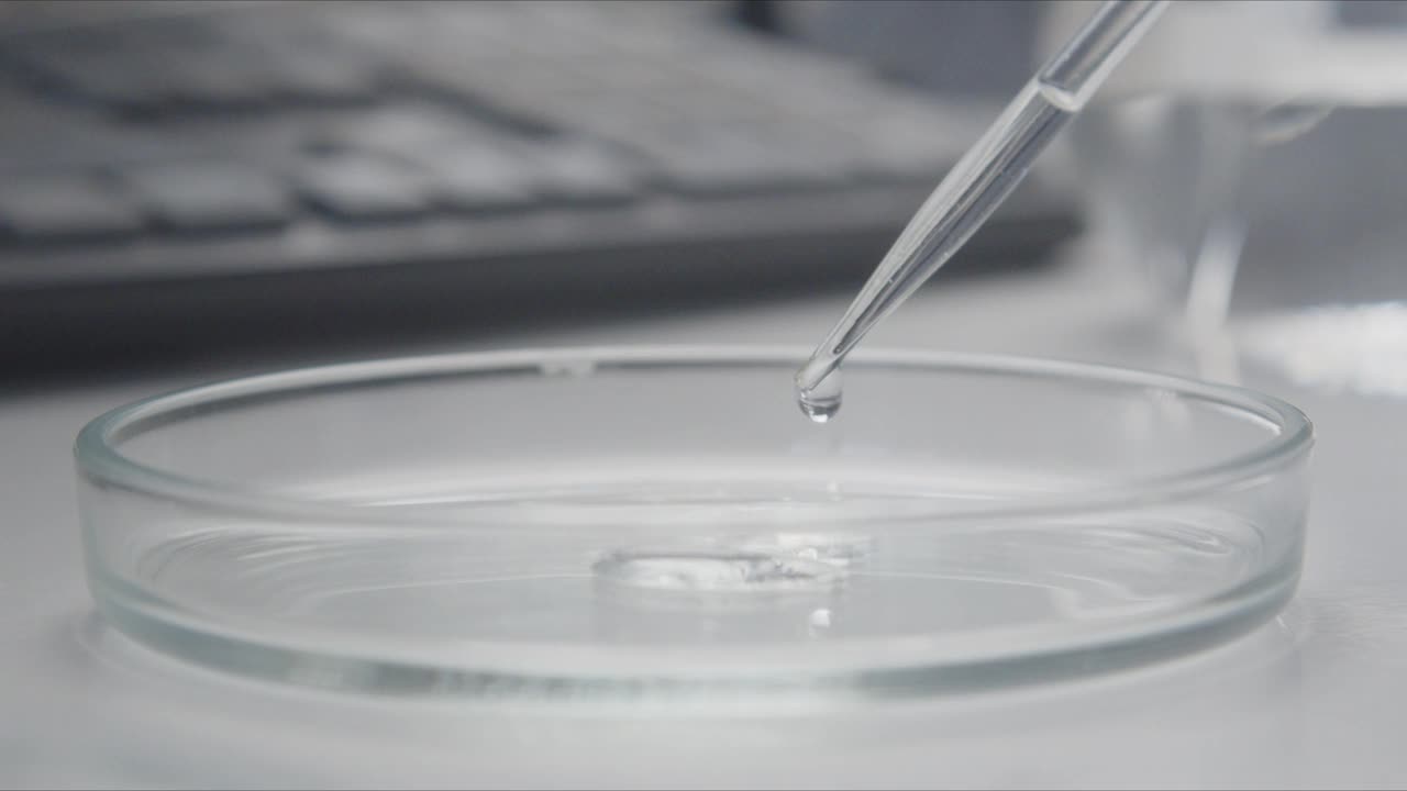 液体从滴管滴入培养皿的特写视频素材