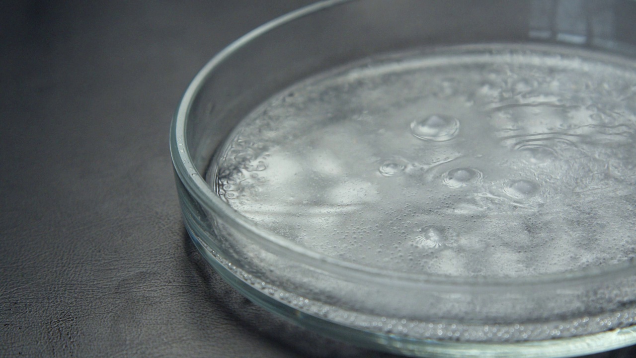 用透明液体取代白色干燥物质的过程，同时释放氧气气泡并形成泡沫视频下载