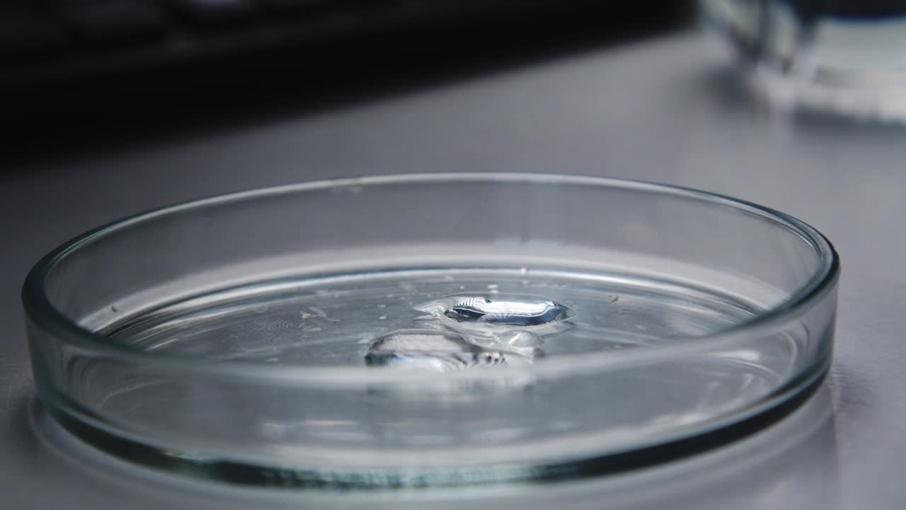 【特写】一种清澈的液体滴在开始融化的干燥的白色物质上。实验室测试。反应与催化剂视频素材