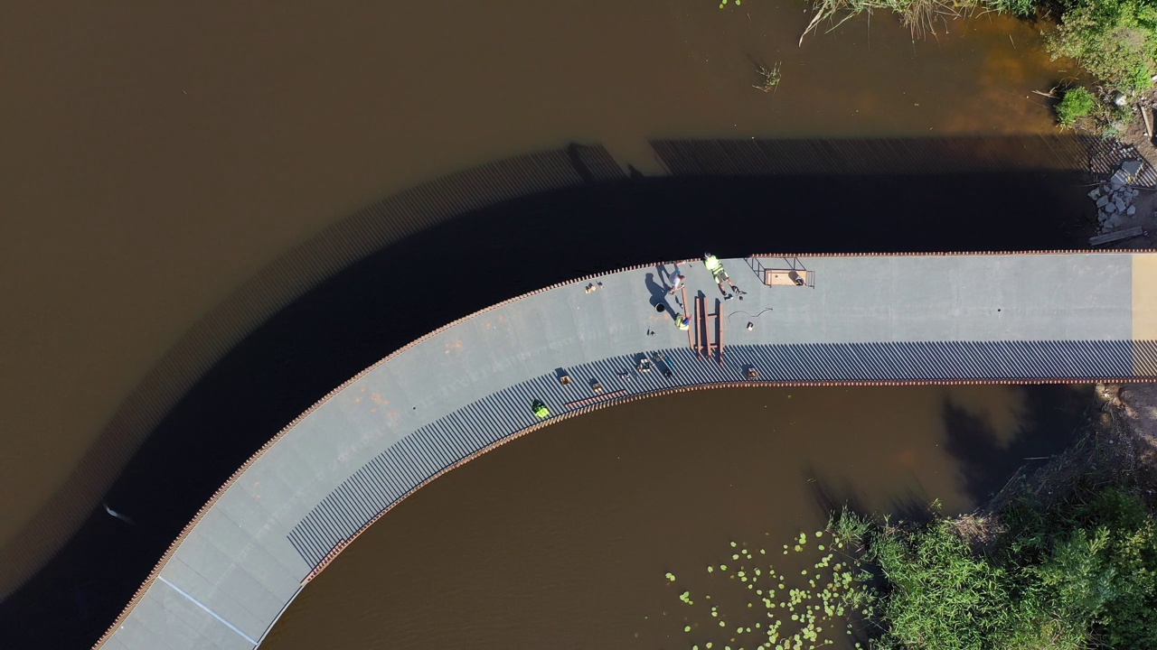 河上人行天桥的木栏杆正在固定，架空视频下载