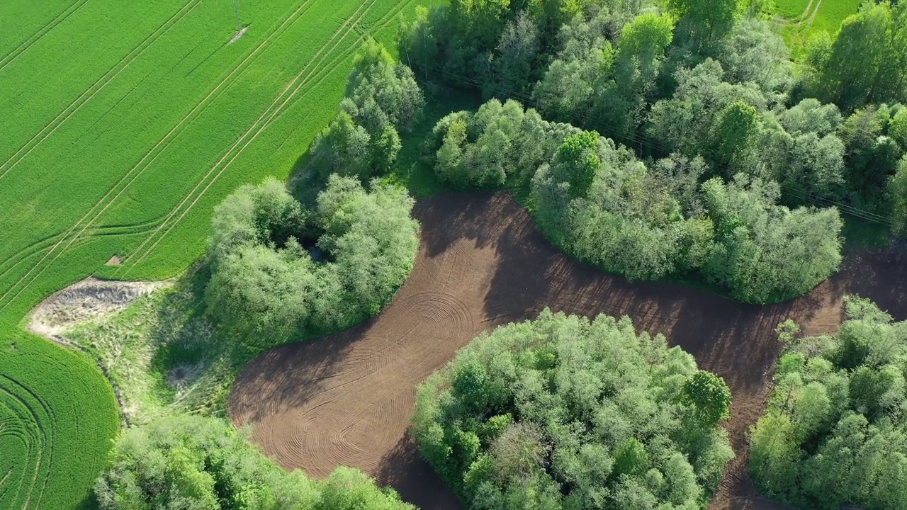 春天的土地上有农田和树林，空中视频下载