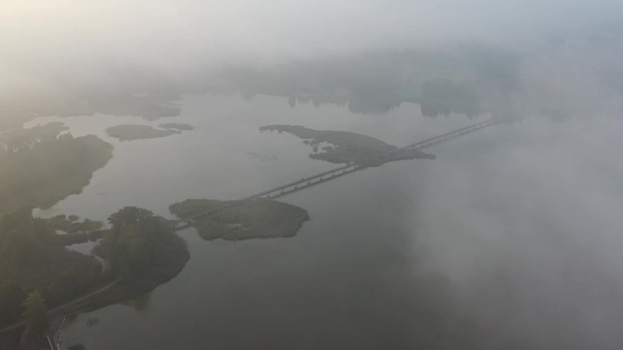 晨雾笼罩湖面和长长的木桥，架空视频下载