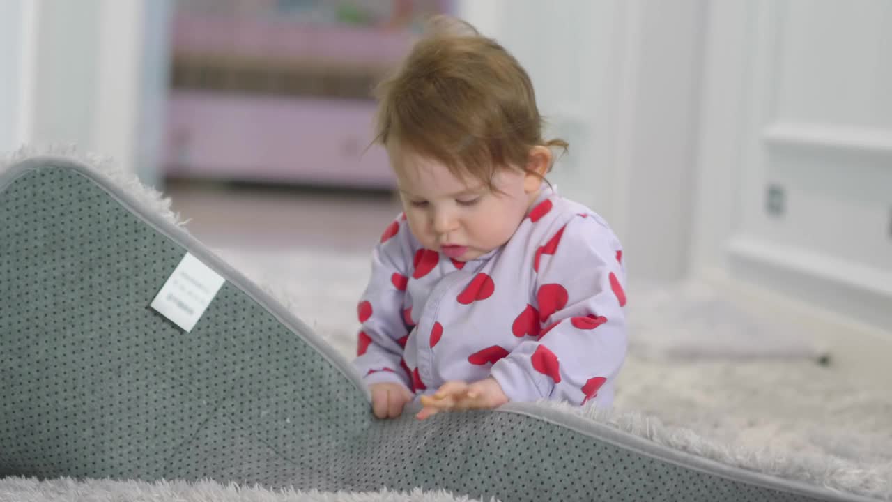 一个欢快的婴儿在舒适的地毯上与一个柔软的玩具互动，画面为4k慢动作，每秒60帧视频下载