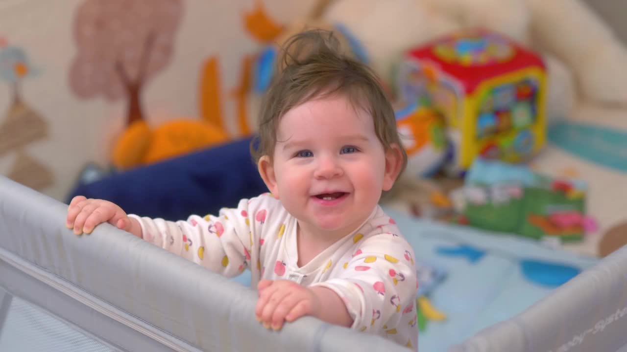 快乐的宝宝站在围栏里，笑着伸出手去玩周围的玩具，4k慢动作60帧视频下载