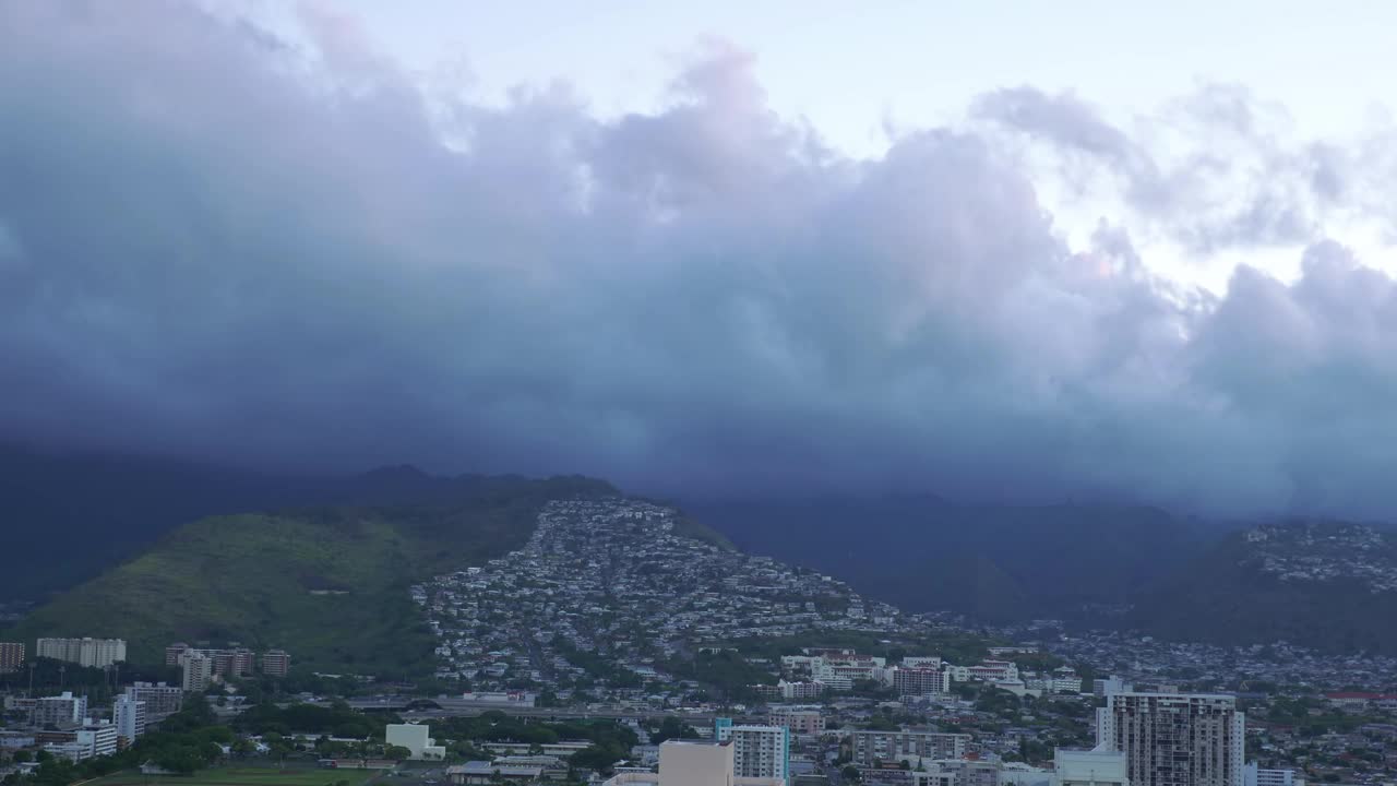 戏剧性的黄昏云在火奴鲁鲁天际线上滚动的延时视频，在4k中变化的光线视频下载
