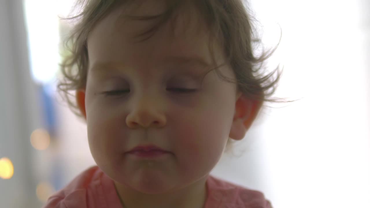 宝宝用一种好奇的表情伸向相机，在4k慢动作60fps的软焦中视频下载