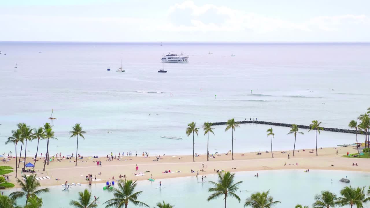 风景秀丽的檀香山海岸线，拥挤的海滩和高耸的酒店，4k慢动作60fps视频下载