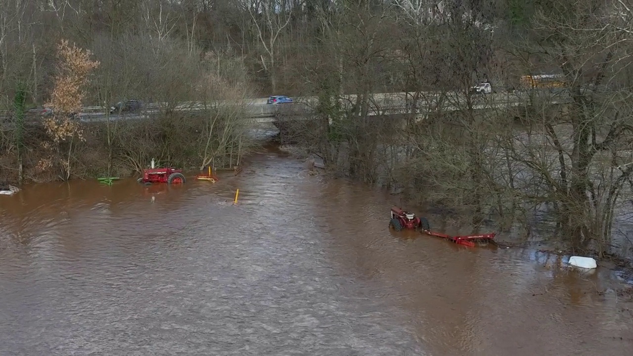 洪水航拍图。农用设备，包括被水浸透的拖拉机。视频下载