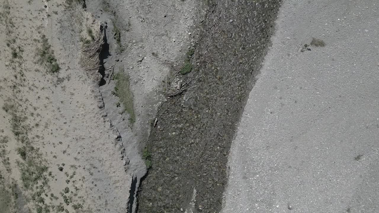 无人机拍摄的自上而下的画面，一条小河蜿蜒流向一个湖泊视频下载