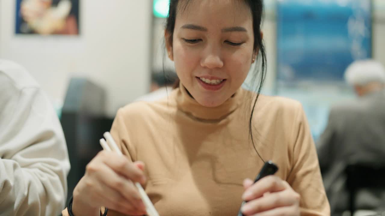 一位年轻女子用筷子吃饭的正面照片视频下载
