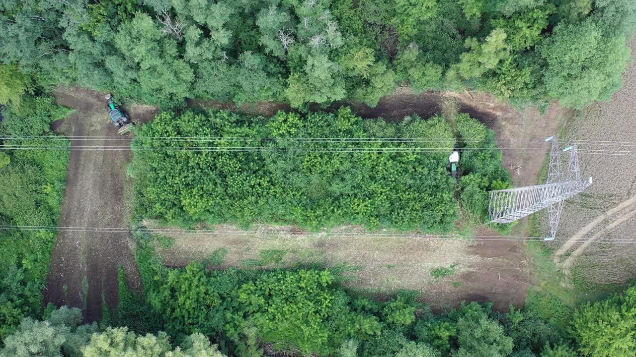 拖拉机清理高压电线下的灌木丛视频下载
