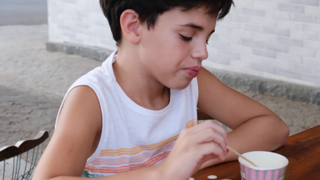 一个阳光明媚的下午，一个10岁的巴西孩子正在吃冰淇淋。视频下载