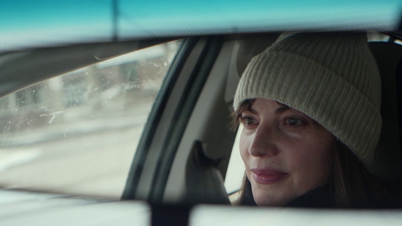 冬天的喜悦:快乐的女人开车，从后视镜看视频下载