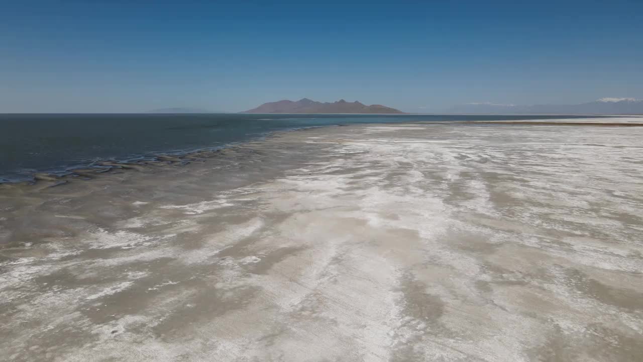 一架4K无人机拍摄了完全平坦的博纳维尔盐滩，位于犹他州西部的大盐湖以西，一层浅层积水淹没了广阔的盐平原表面。视频下载