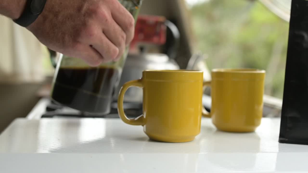 用手，法式压壶和咖啡与人一起在厨房准备咖啡因饮料的特写。早上，在公寓里用杯子或马克杯和大人一起倒热饮，开始日常生活视频下载