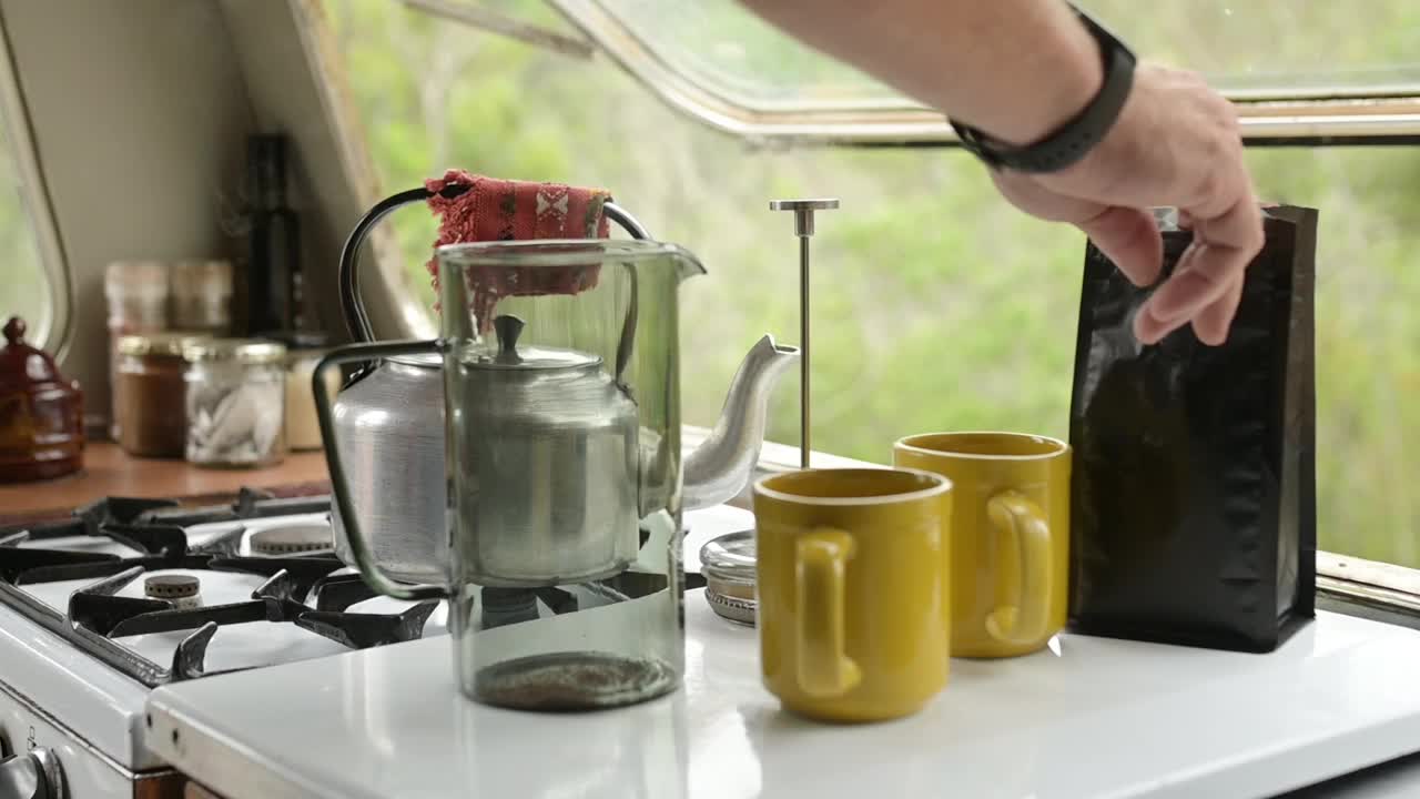 手，法压壶和咖啡粉与人在家庭厨房准备咖啡因饮料的特写。早上，在公寓开始或开始日常工作时，杯子或马克杯和倒饮料视频下载