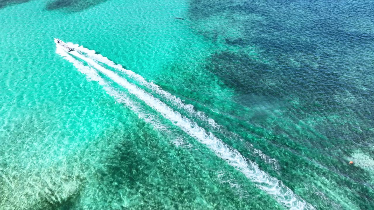 航拍全景视图的珊瑚礁和游泳池在加勒比海和航行快艇在水中4k视频视频下载