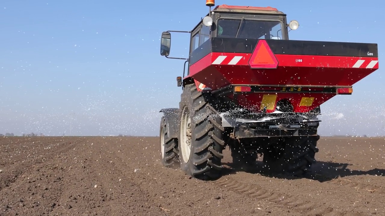 春天，农民用农机给农田施肥，慢动作视频下载