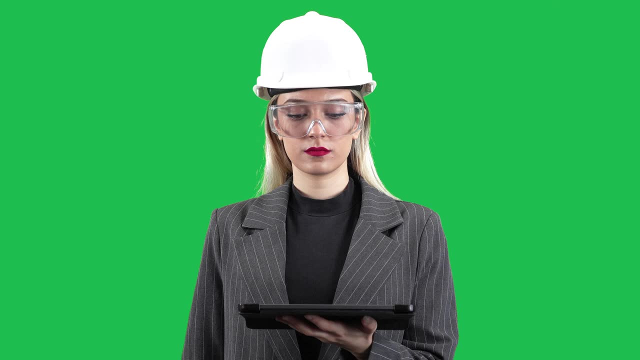 绿幕女土木工程选择透明显示全息图上的数据，穿着防护服的女建筑师使用数字平板电脑。使用未来科技的女商人。概念:沉浸式技术，未来概念。视频下载
