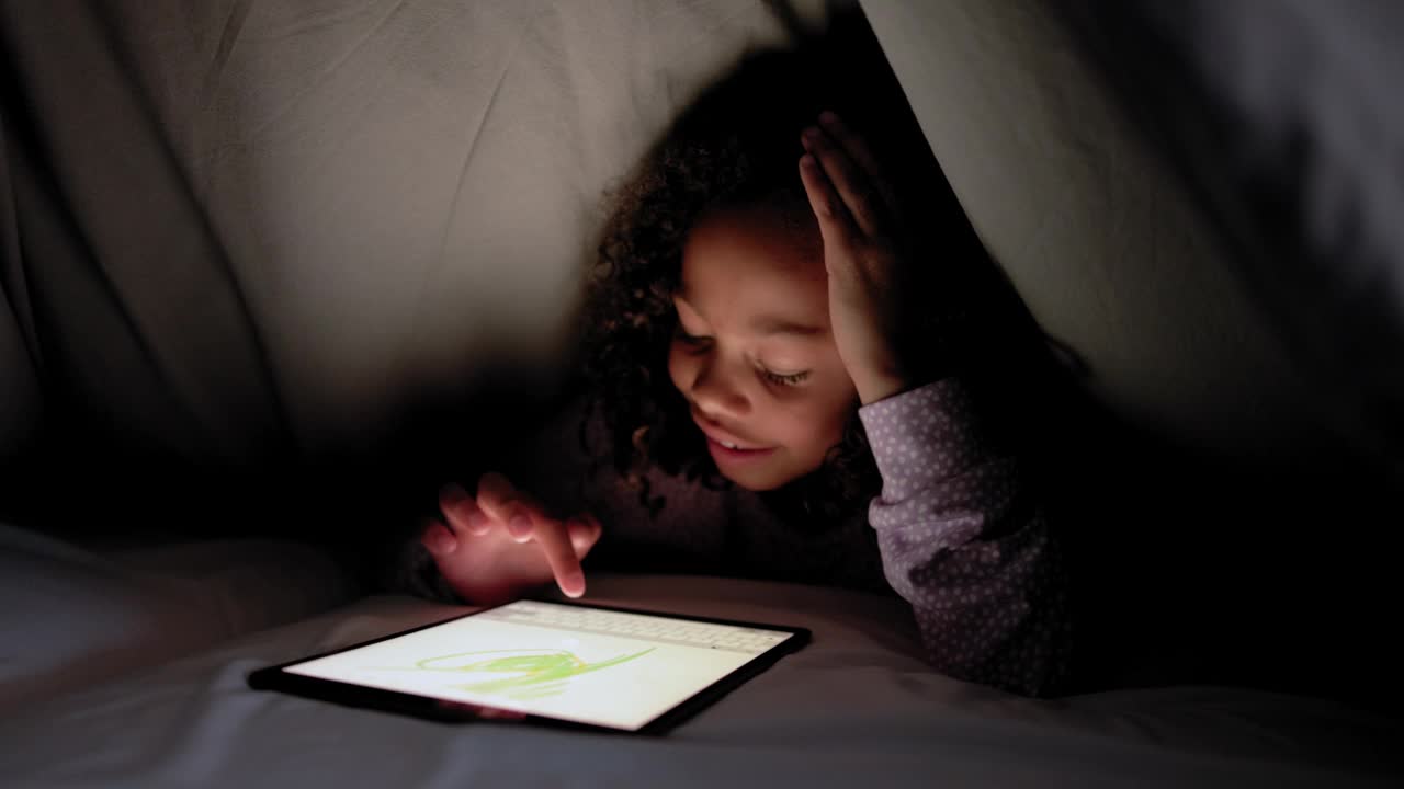 小女孩晚上盖着毯子玩数码平板电脑视频下载