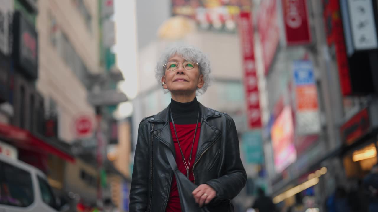 时尚的亚洲老年女性自信地走在街上视频下载