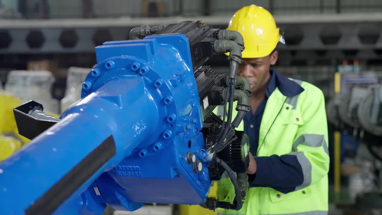 非裔美国工程师、技术员在焊接工厂用螺丝刀检查机器人机械臂视频素材