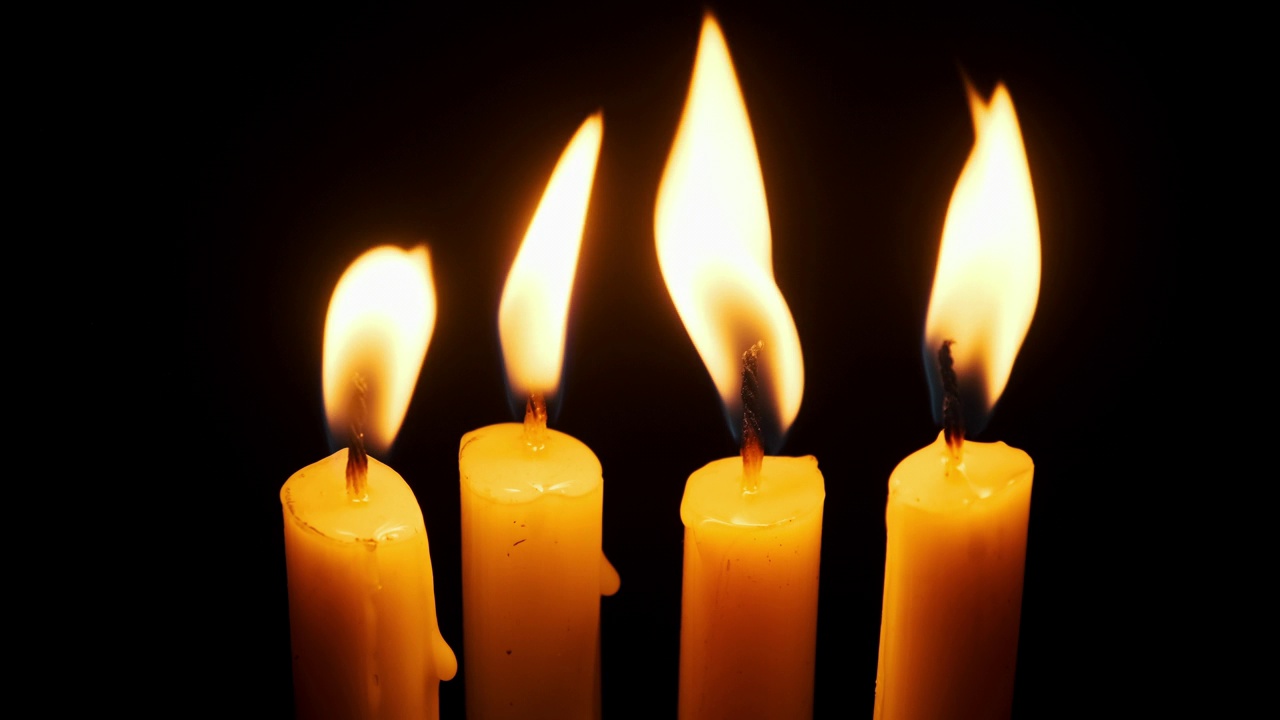 四支蜡烛在黑色背景上燃烧和熄灭，复制空间视频下载