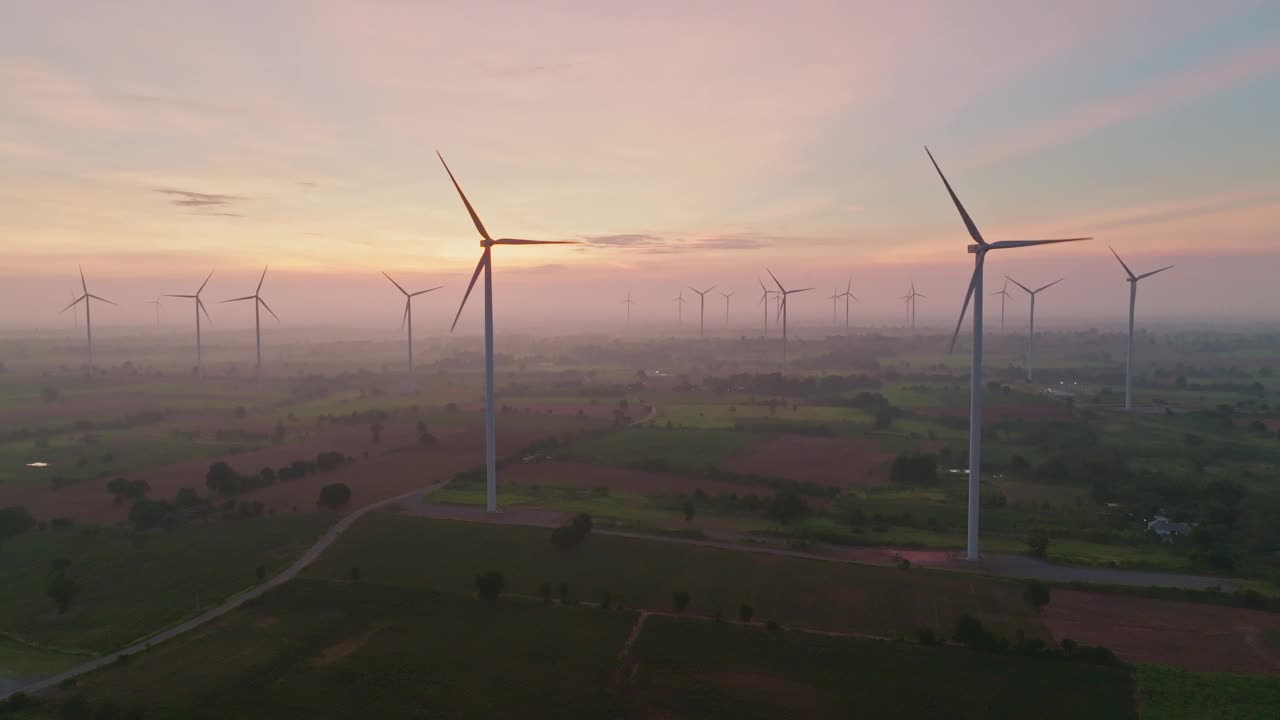 风力涡轮机农场鸟瞰图，美丽的日出创造可再生能源视频下载