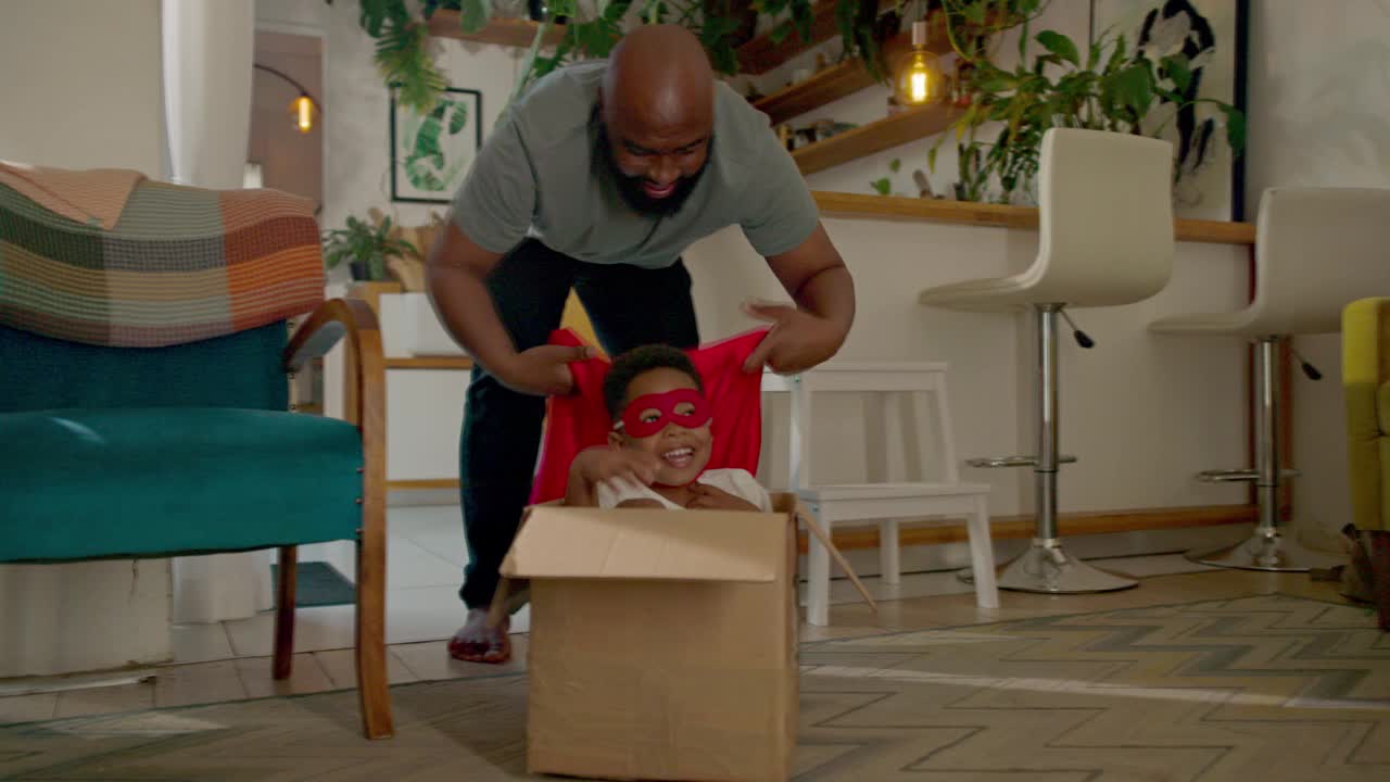 一个溺爱儿子的父亲在他们的生活空间里用纸板箱鼓励儿子的创造力视频下载