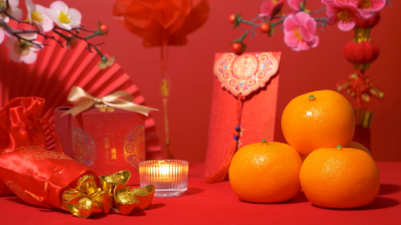 中国农历新年的红色背景环。中国古代金条在丝绸袋、礼品盒、纸扇、红包、橘子、梅花枝、蜡烛和红纸灯笼挂饰视频下载
