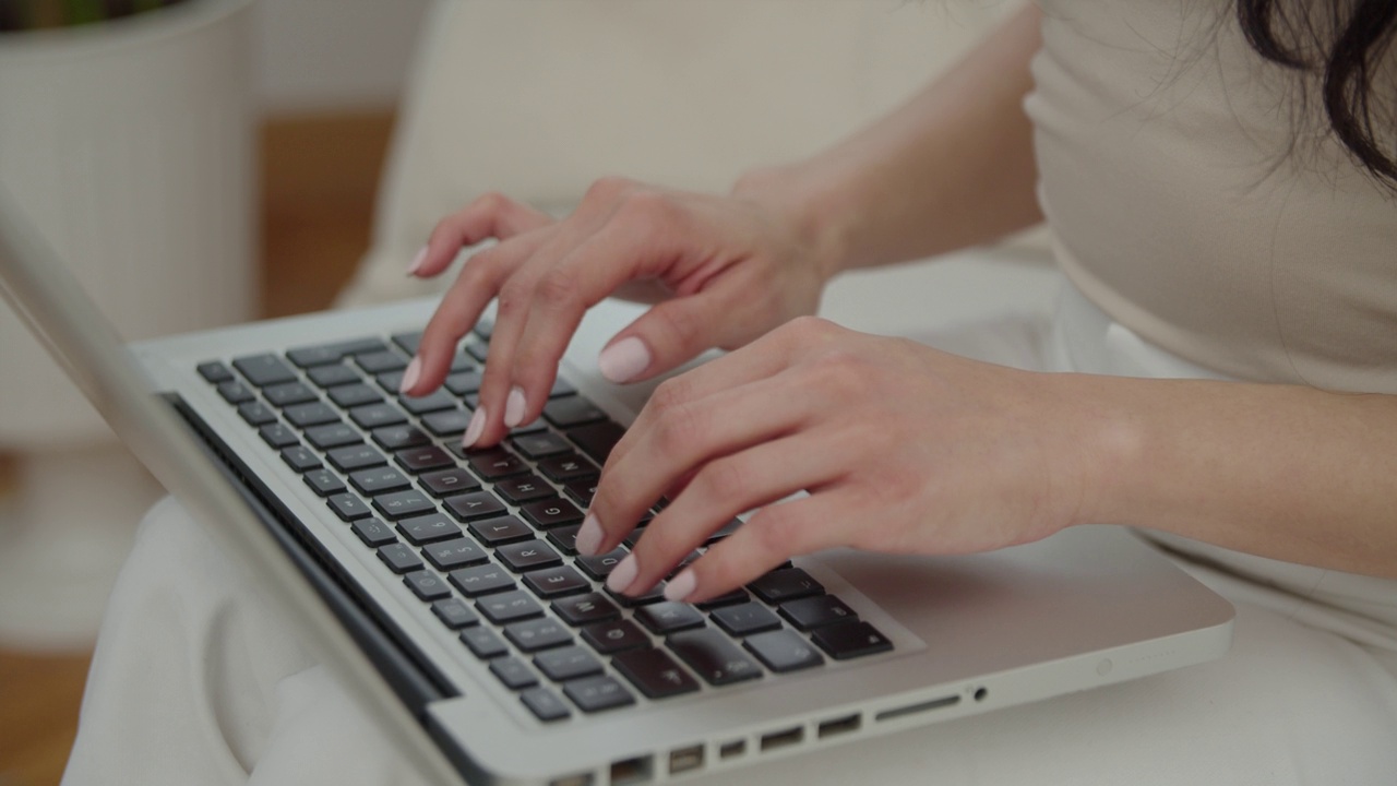女性的手按下笔记本电脑键盘的特写。视频下载
