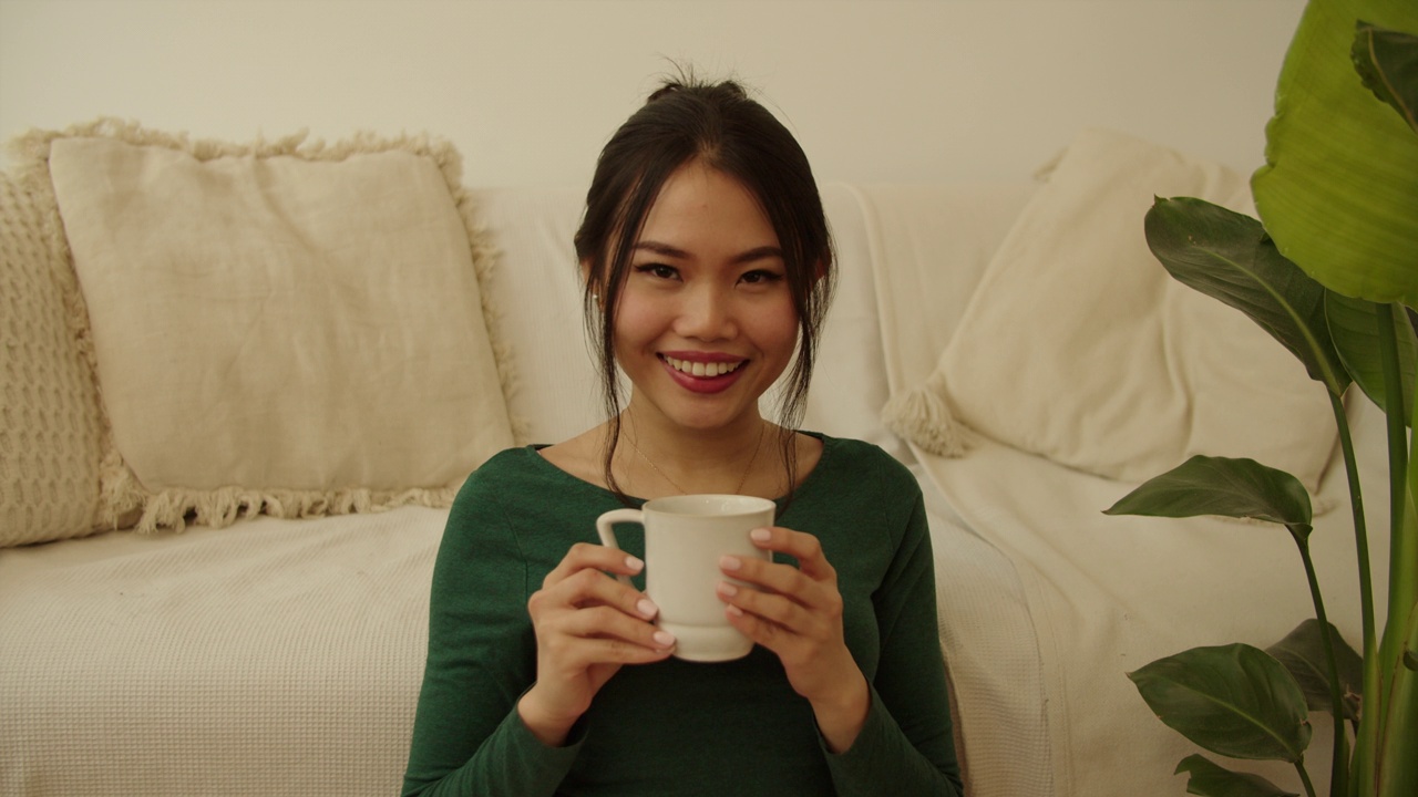 一个年轻女子在家喝咖啡或茶的画像。视频下载