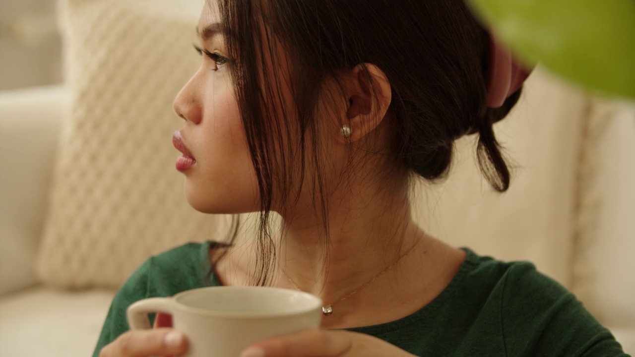 一个年轻女子在家喝咖啡或茶的画像。视频下载