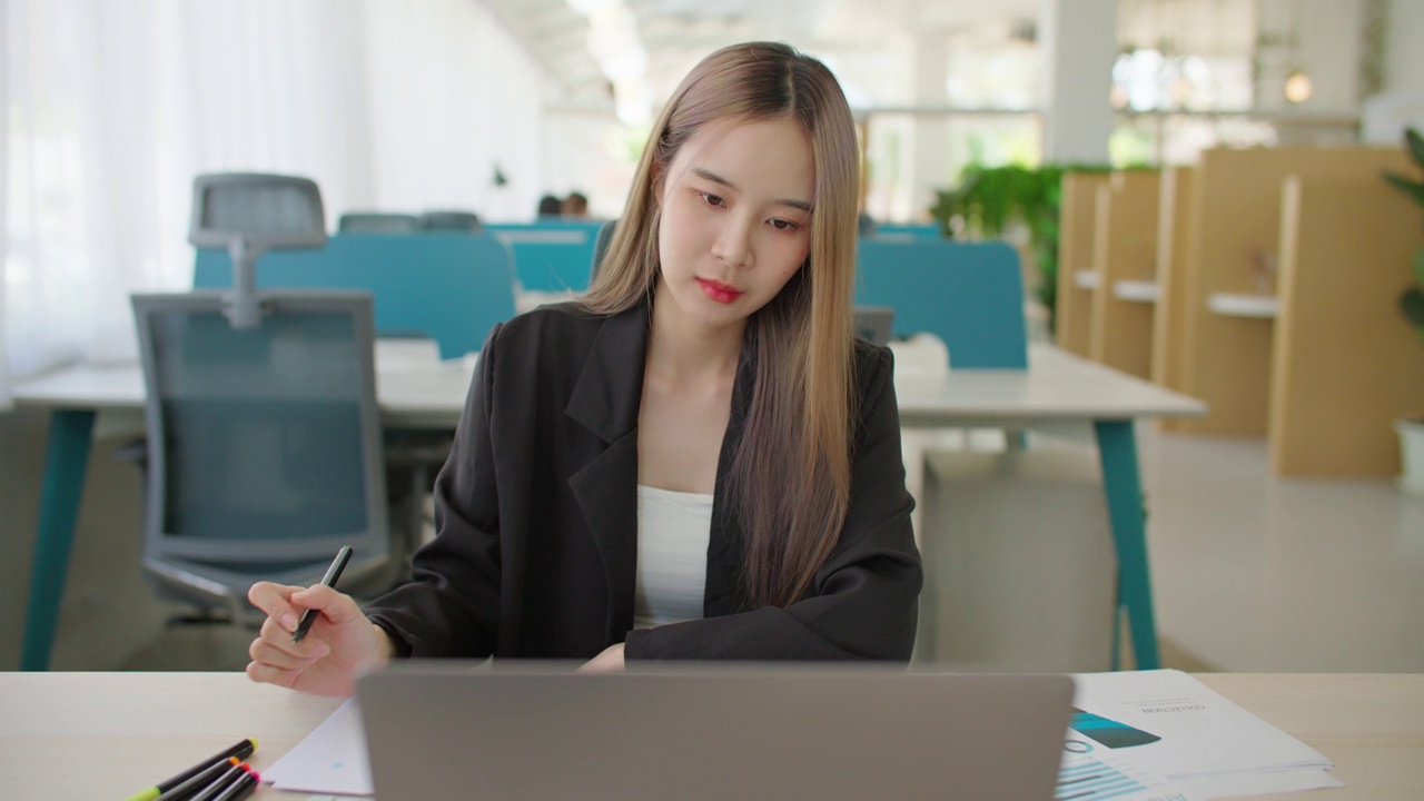 亚洲女商人打开笔记本电脑，从事数据分析项目文书工作。视频下载