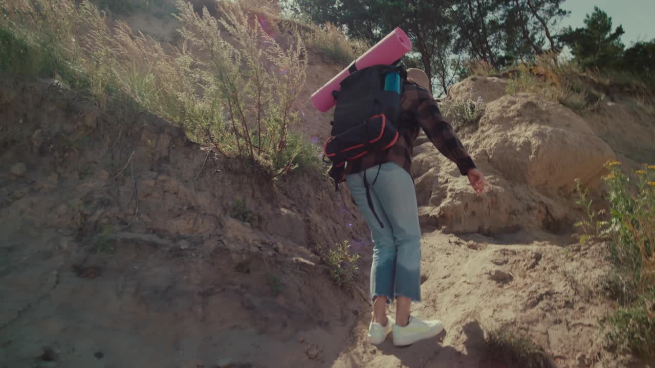 背着背包的女旅行者正在爬山视频下载