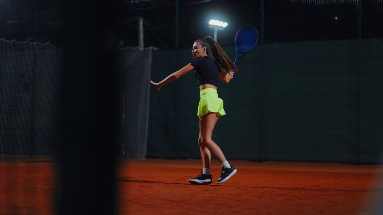 女子单打网球运动员夜间在球场训练，户外全身像视频下载