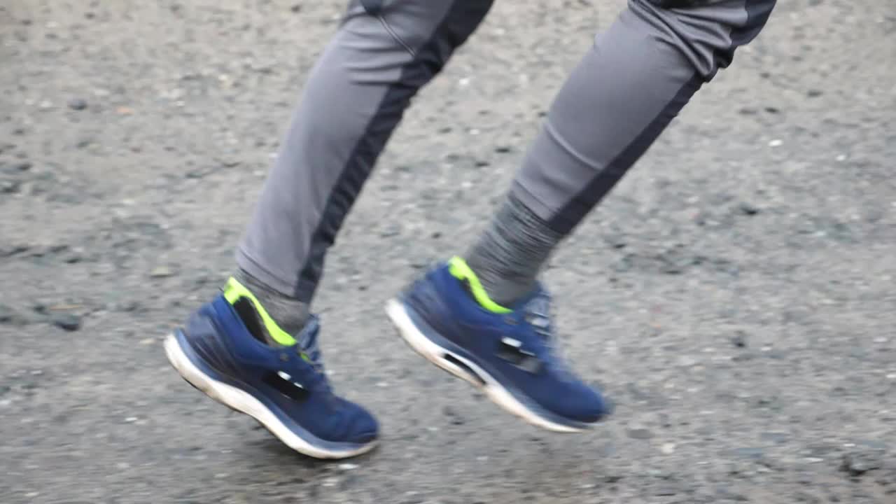 运动型男子沿着乡间小路奔跑的双脚。年轻运动员沿着乡间小路慢跑的双腿。穿着运动服进行有氧运动训练的强壮耐力运动员。积极生活方式概念视频下载