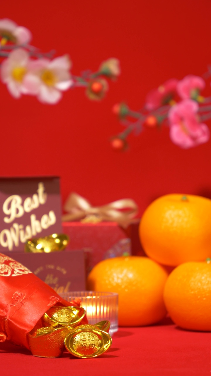 中国农历新年的红色背景环。中国古代金条装在丝绸袋子里，礼盒里有文字祝福，橘子、纸扇、梅花、蜡烛摇曳在春节庆祝上视频下载