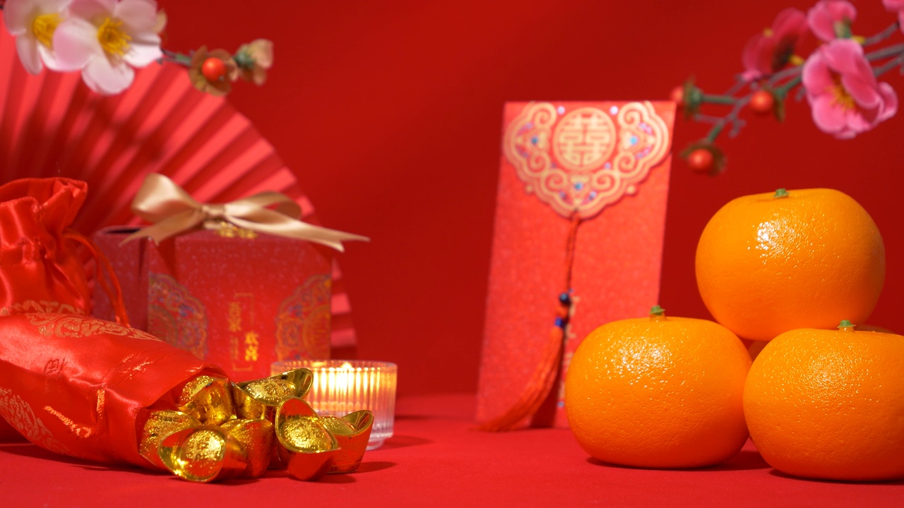 中国农历新年的红色背景环。中国古代金条装丝袋，红包，红包，红包，有文字祝福的红色礼盒，橘子，纸扇，梅花，蜡烛视频下载