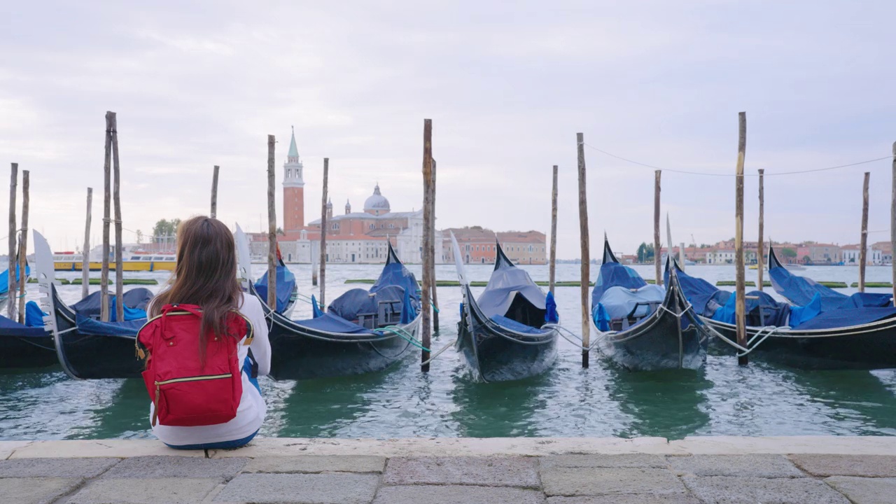 欧洲，意大利，威尼斯，女子坐着看大运河的后视图。视频下载