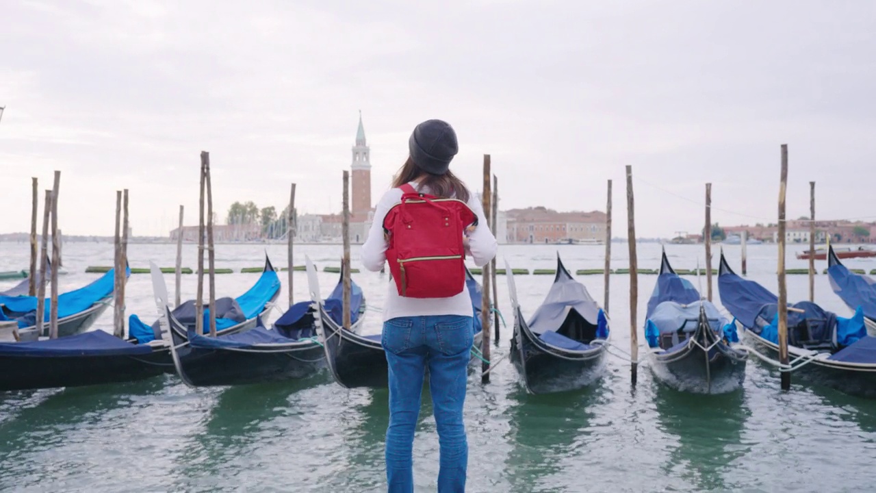 后视图，快乐的女游客参观意大利威尼斯著名的地标，在上午，欧洲的意大利。视频下载
