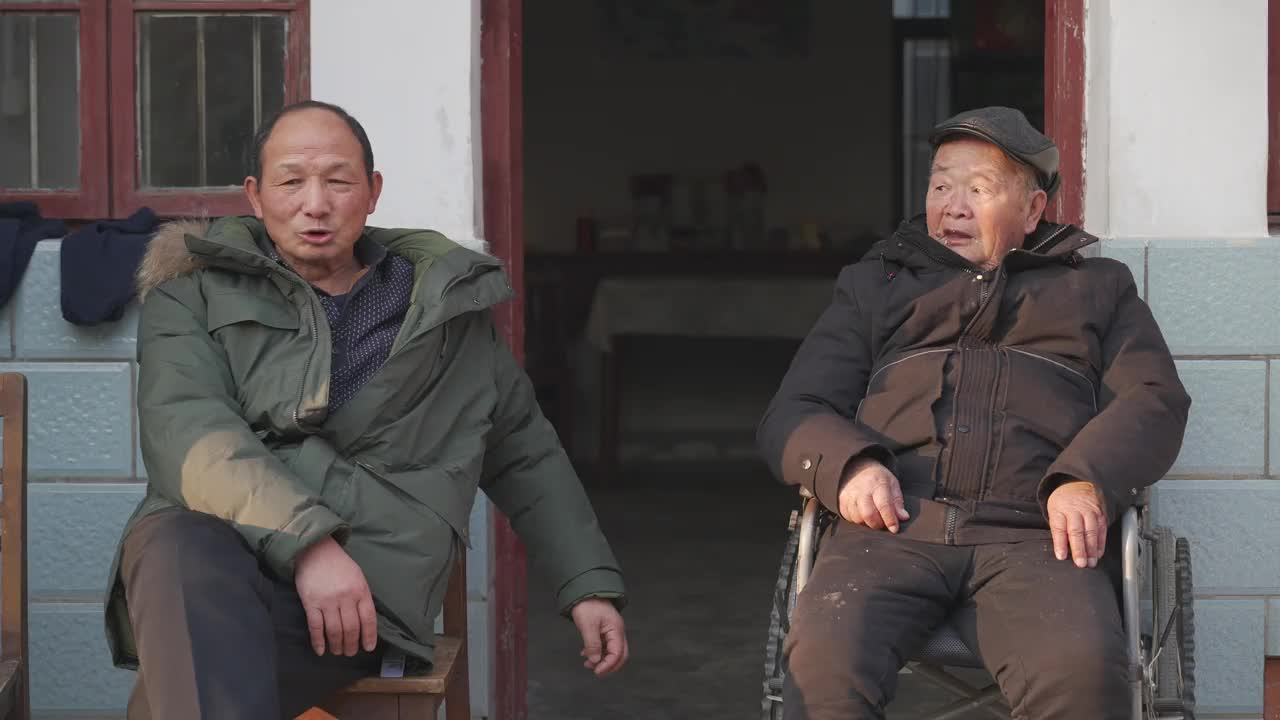 父子俩坐在门口聊天，老父亲坐在轮椅上，老人照护，人口老龄化视频素材