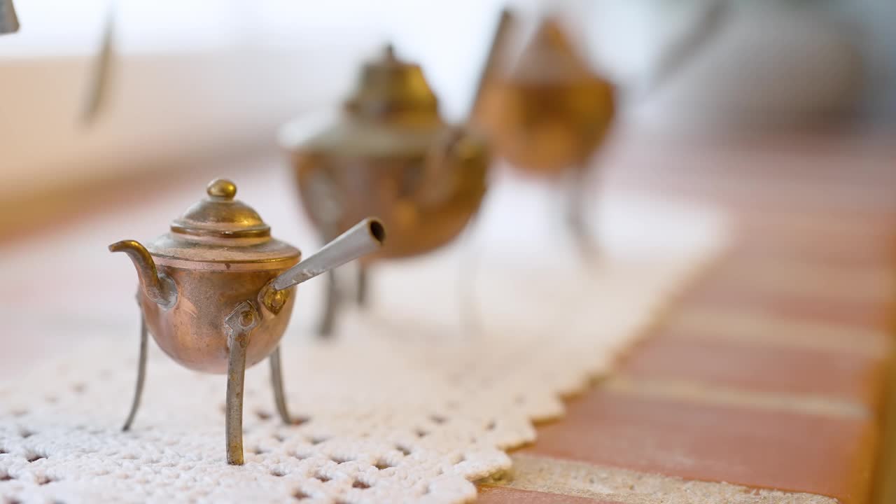 复古黄铜茶壶上的花边桌布和木桌视频下载